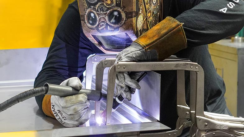 Infinity Drain factory worker welding a pipe